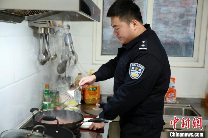 图为民警在做饭。　杨兵 摄