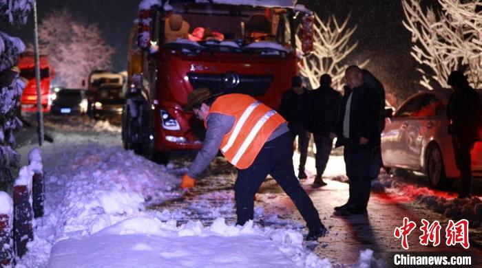 工作人员正在清除路面积雪。　易恒戬 　摄