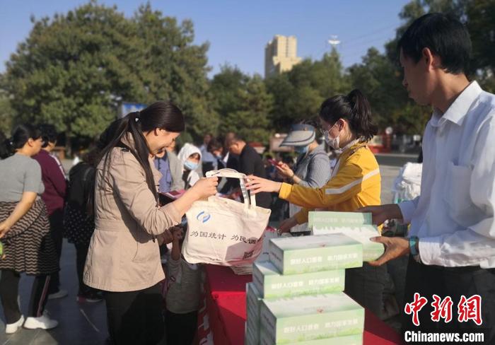 图为兰州市民领取人口普查知识宣传页。(资料图) 杜萍 摄