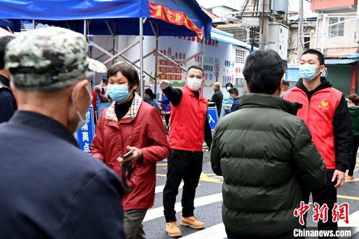 龙溪搏击馆馆长阮沈滨(红马甲左)与队员在芗城区通北街道协助维护核酸检测的现场秩序。　张金川 摄