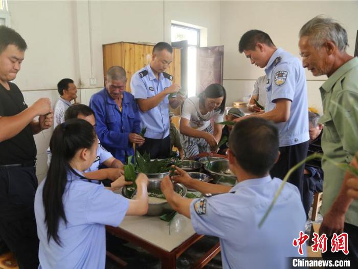 图为小坝子边境派出所民警与敬老院老人一起包粽子。　小坝子边境派出所供图