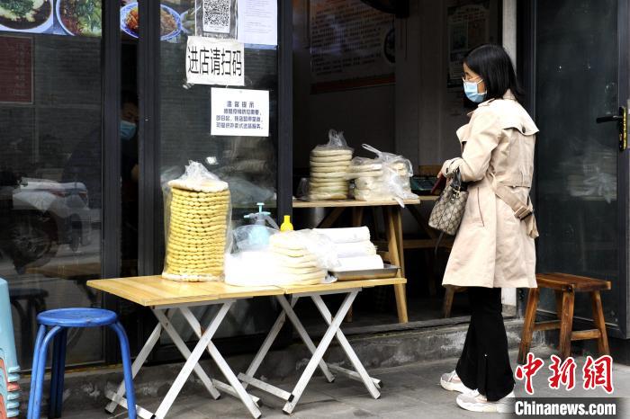 图为民众在餐馆门口等待商家打包食物。　高铖 摄