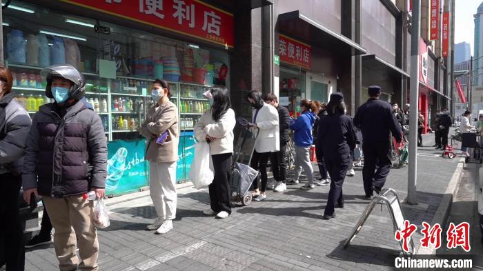 部分服装店老板正依次排队等候，出示48小时核酸证明、场所码，经测温并在安检口登记后进入商场“取货”。　上海静安警方供图