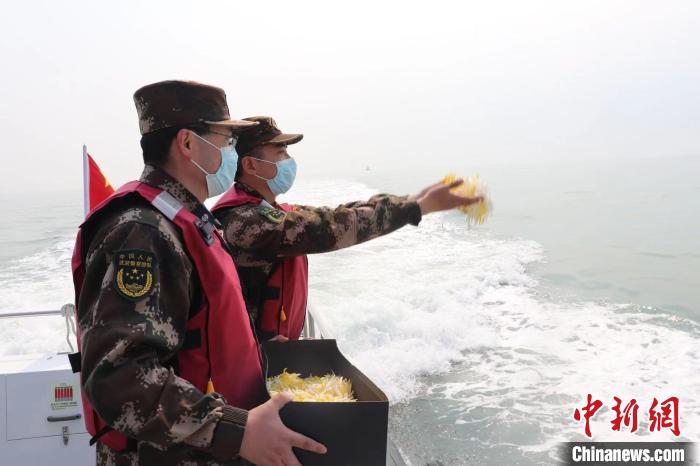 东营海警局执法人员在清明节期间向大海撒花祭奠。山东海警局供图