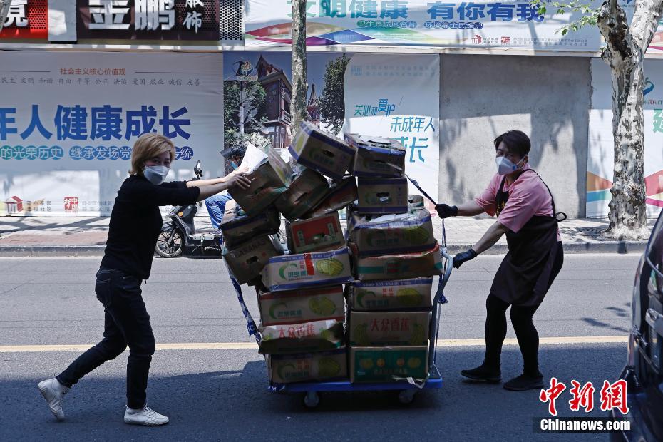 4月12日，上海愚园路元华超市，工作人员将准备好的蔬菜运至周边小区。 中新社记者 殷立勤 摄