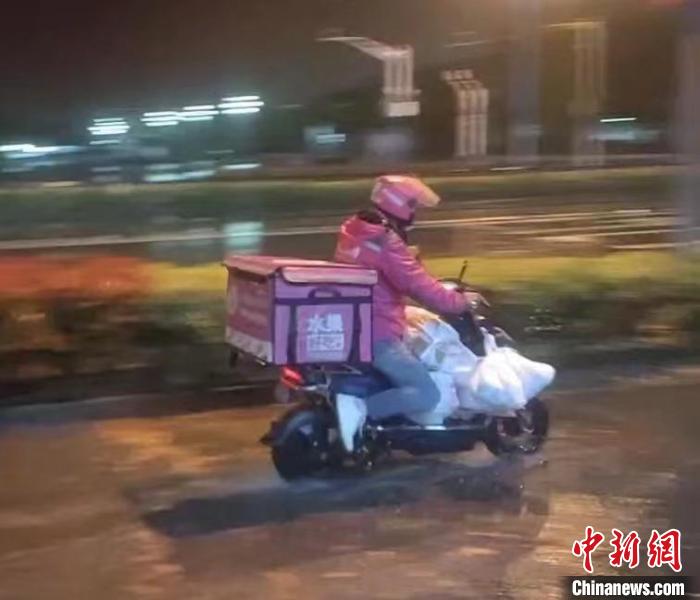 大雨天，叶国贝骑行在送菜的路上 受访者供图