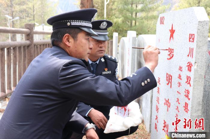 图为帕里边境派出所民警为革命烈士墓碑描红。　日喀则边境管理支队 摄