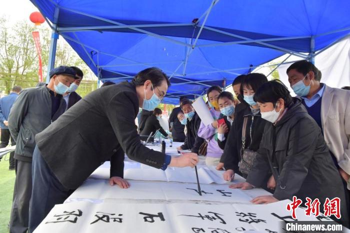 在活动现场，甘肃省定西市漳县民众，围观、欣赏书法爱好者挥毫泼墨。　闫姣 摄