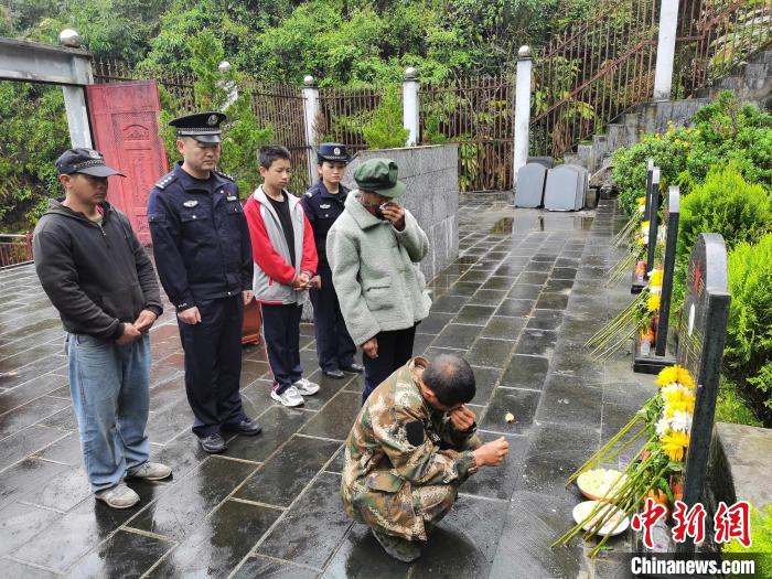 图为齐春珍一家在民警陪同下为齐当此扫墓。　独龙江边境派出所供图