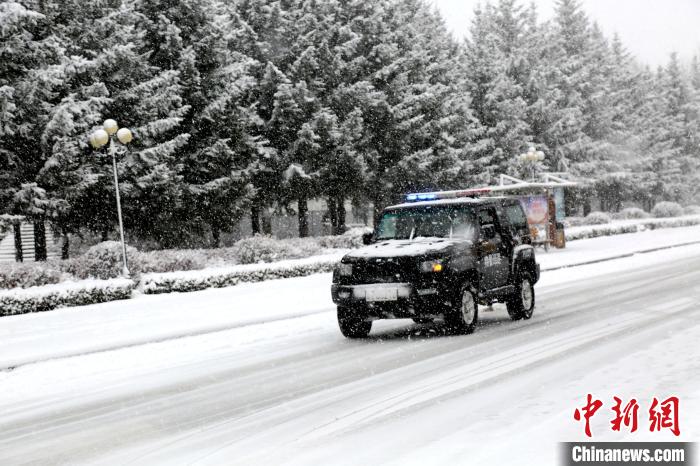 警车冒雪在街上巡逻。　冯宏伟 摄