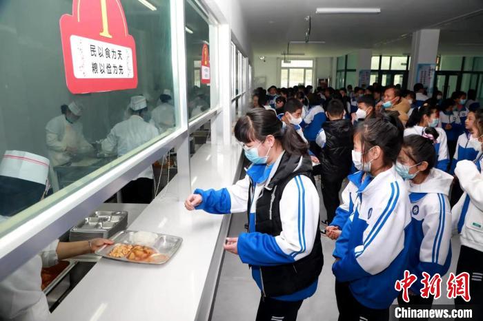 图为海东市民和县中学生在食堂打饭。(资料图) 石延寿 摄