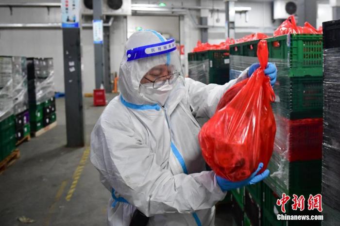 图为4月14日，上海市普陀区一处物流园，进驻临时大仓的盒马西安区域物流负责人秦幽在检查蔬果的品质。 中新社记者 田雨昊 摄