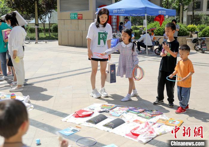 孩子们在“跳蚤市场”玩套圈游戏。　陈康 摄