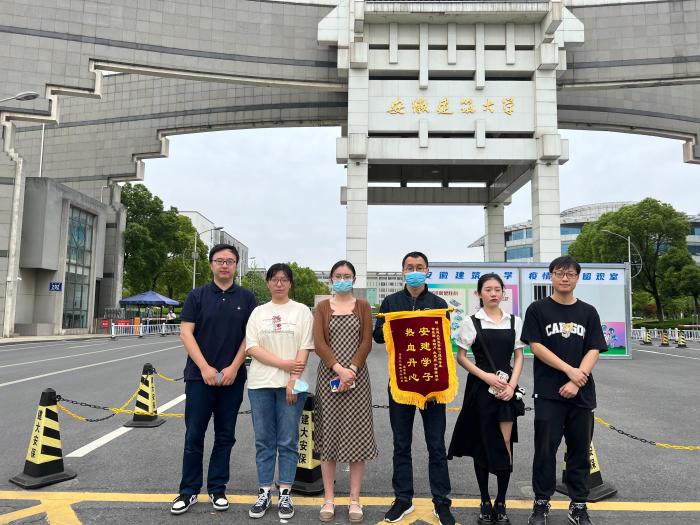 4名学生与锦旗合影。　安徽建筑大学供图