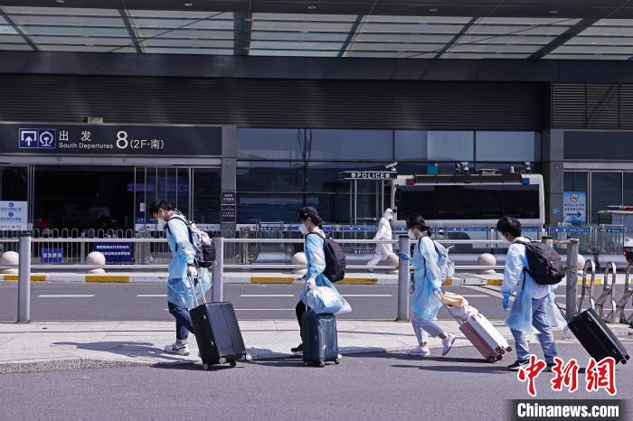 旅客提着行李在铁路上海虹桥站外行走。　殷立勤 摄