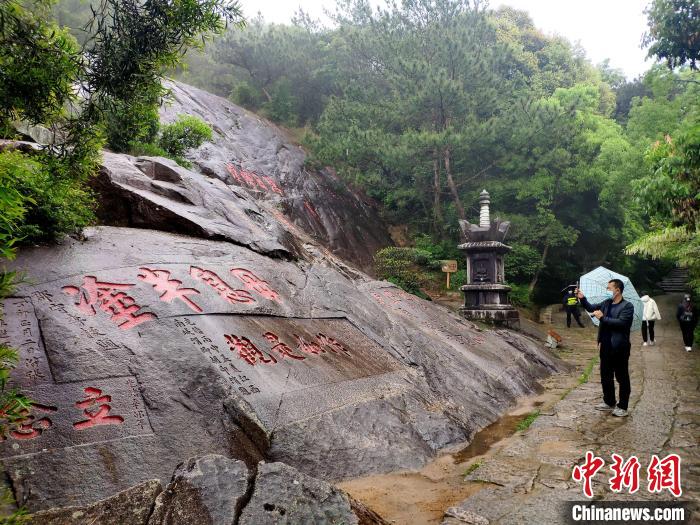 图为鼓山上的摩崖石刻吸引游客。　吕明 摄