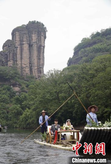 5月20日，新人乘坐“百年修得同船渡”主题花筏漂流而下。　周思念 摄