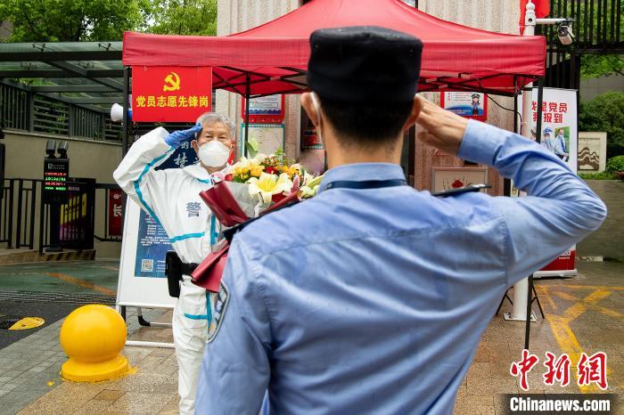 4月28日，胡光明在执勤点光荣退休，派出所民警代表送上祝福献花，老胡眼中满是不舍 宋军 摄