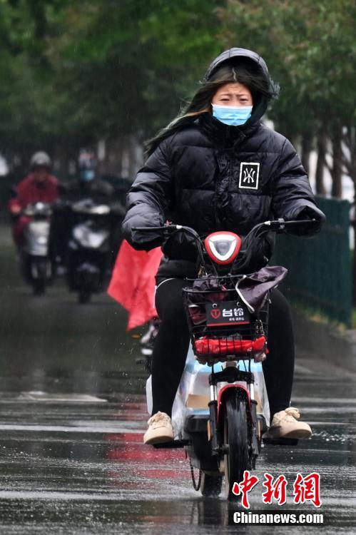 5月8日，河北石家庄，市民着厚装出行。当日，石家庄迎来降雨降温天气。 中新社记者 翟羽佳 摄。