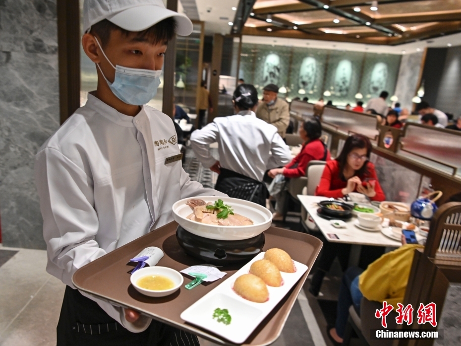 图为2021年2月4日，位于广东省广州市荔湾区第十甫路、有着141年历史的茶楼“陶陶居”总店，经过约两年半的修缮后重开迎客，一名服务员为顾客送餐。（资料图） 中新社记者 陈骥旻 摄