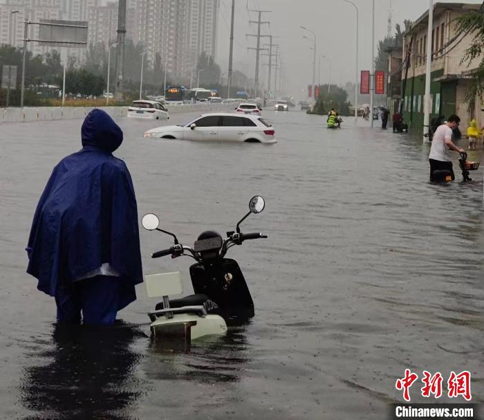 银川发生暴雨天气，市民在积水中跋涉。　张怡 摄