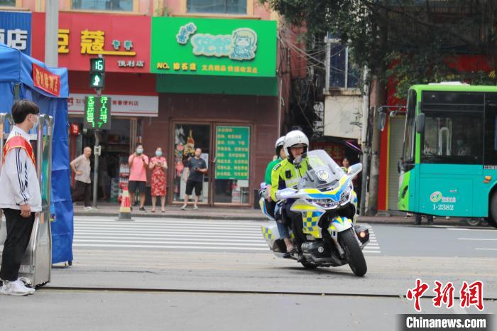 6月7日，一名考生忘记证件和文具，柳州交警机动大队民警刘华驾驶警用摩托车载着考生家长飞奔在路上。　受访者提供