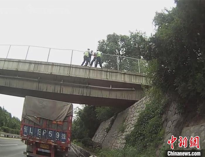 两名民警在少女父亲的配合下，奋力将其拖回安全地带。　高速交警供图