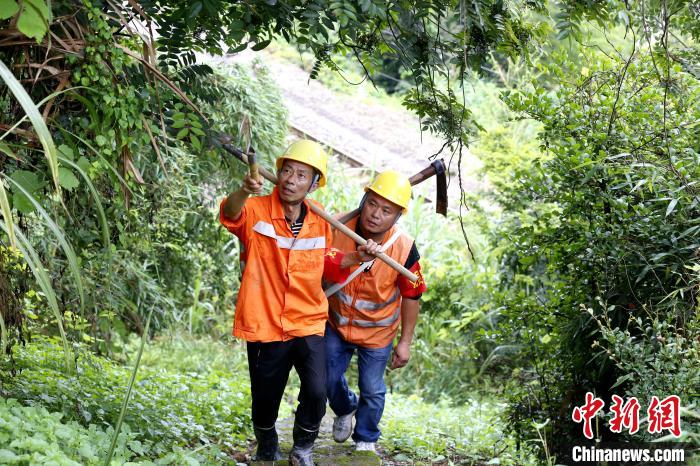 图为6月16日，黄荣福与工友携带工具前往鹰厦铁路上房山至荆西区间抢险点进行清淤作业。　丁波 摄