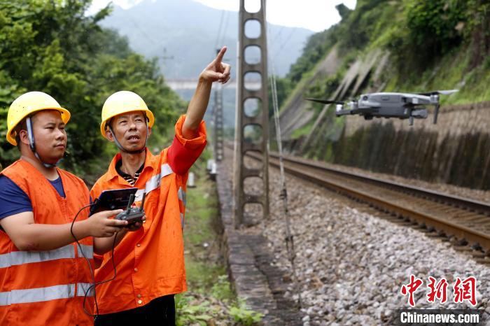 图为6月16日，黄荣福与工友利用无人机在鹰厦铁路上房山至荆西区间检查路桥设备安全状态。　丁波 摄