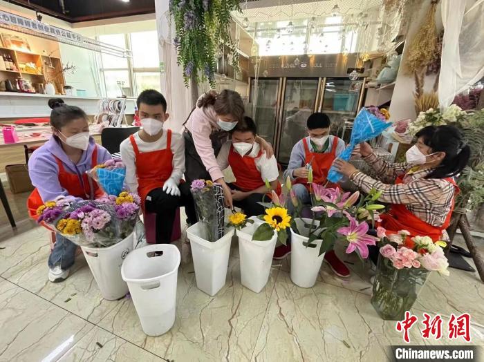 威威(右二)和小伙伴们在家长们的指导下给鲜花换水。　刘栋 摄