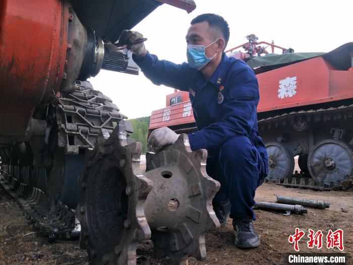 资料图。图为王杰正在日常维护他心爱的装甲车。　王杰供图