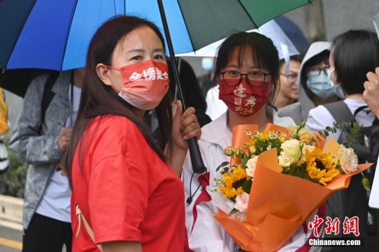 6月8日，全国部分地区2022年高考结束。图为家长戴“金榜题名”口罩在昆明市北清实验学校考点外迎接考生。当日，云南省2022年高考落幕。 中新社记者 李嘉娴 摄