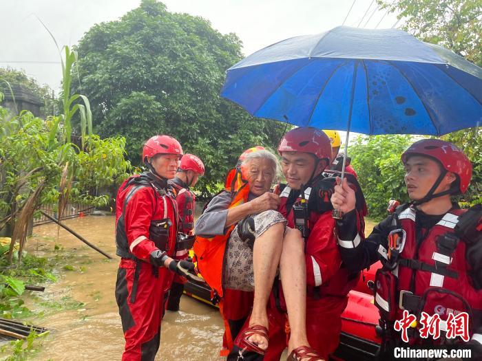 消防救援人员转移被困民众。　程雨杰 摄