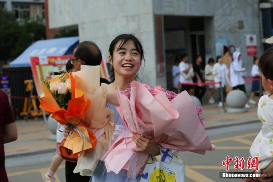 6月8日，在四川眉山市东坡中学考点外，考生在考试结束后收到家长送上的鲜花。 中新社发 姚永亮 摄 图片来源：CNSphoto