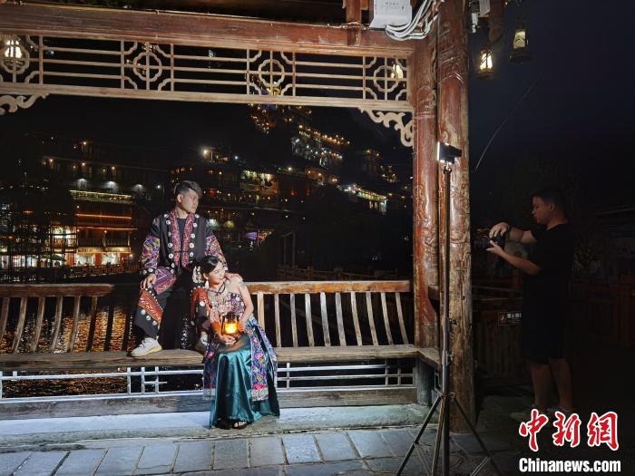 图为游客在西江千户苗寨的风雨桥上拍照。　周燕玲 摄