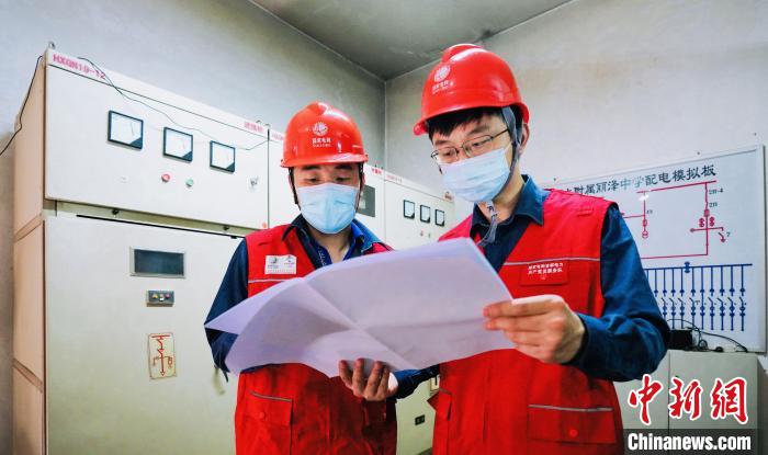 6月6日，国网北京丰台供电公司员工在丽泽中学为客户检查用电设备，保障高考期间可靠供电。　张涛 摄