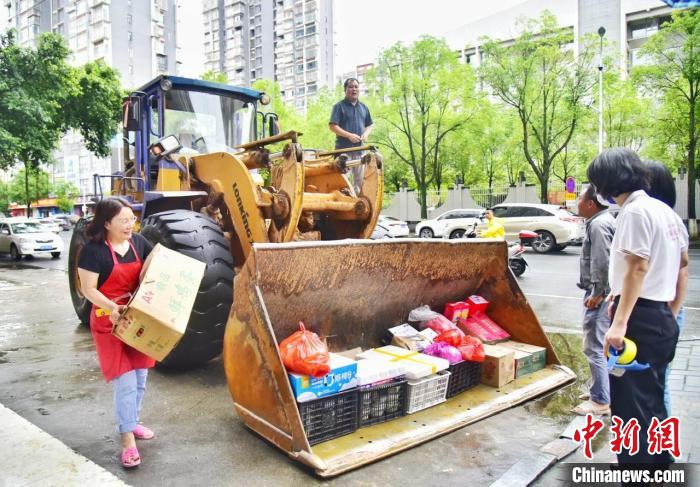 江西省赣州市龙南市大罗社区亲水湾小区业主们准备好的饭菜，被铲车“快递”接走。　叶波 摄