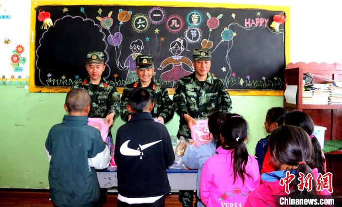 图为武警官兵为小学生赠送学习用品。　杨宁 摄