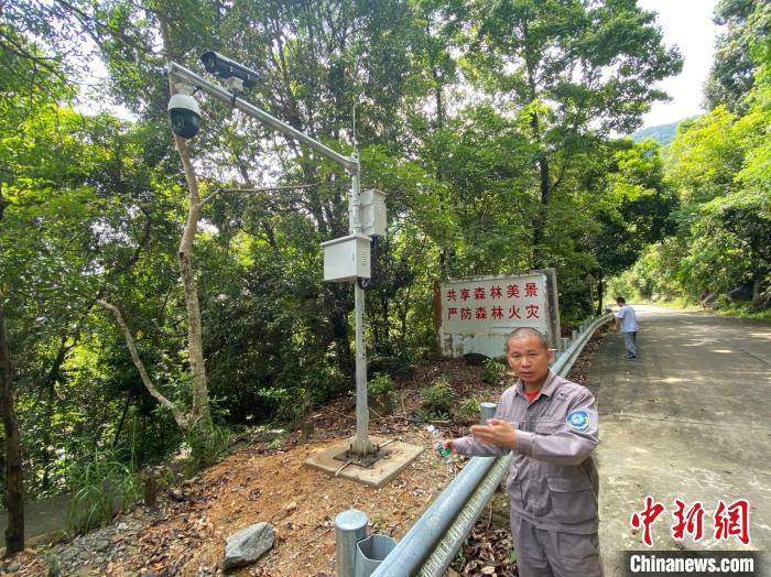 图为海南长臂猿监测队队员杨先珊介绍架设在海南热带雨林国家公园霸王岭片区内的车辆卡口监控相机。　符宇群 摄