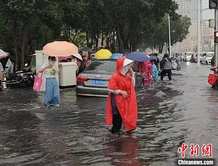 银川发生暴雨天气，市民在积水中跋涉。　张怡 摄