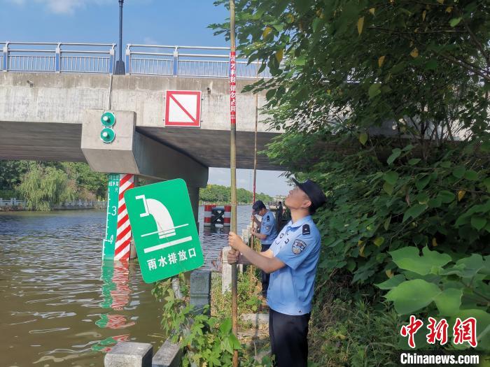 民警在河道危险区域布设救援竹竿。　林其森 摄