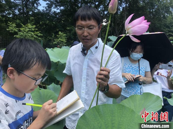 杨东为参观者讲解千年古莲 中科院武汉植物园供图