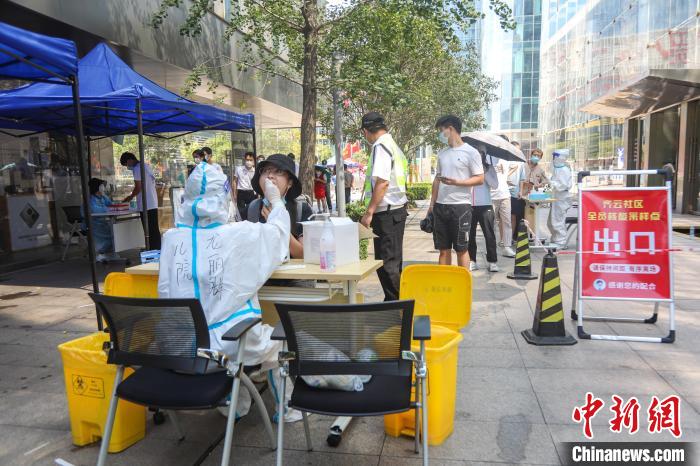 图为南昌红谷滩区一核酸检测点，市民冒着高温有序排队测核酸。　刘力鑫 摄