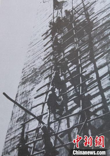 杨连第带领十八名勇士搭架云梯成功登上45米高的8号桥墩顶(翻拍照片)。　王在御 摄