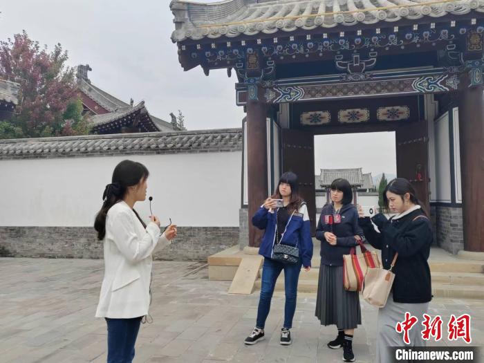 台湾自媒体人正在听解说员讲解高平炎帝陵历史。　高雨晴 摄