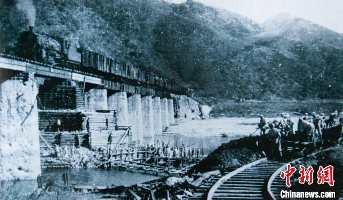 修复后的清川江大桥通过第一列军用列车(翻拍照片)。　庞喻文 摄