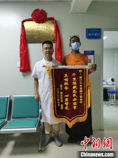 洛追(右)为俞昉(左)送上锦旗。　受访者供图