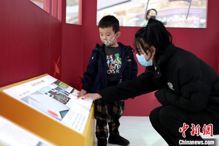 一名母亲带着孩子观看展览。　香港特别行政区政府驻辽宁联络处供图