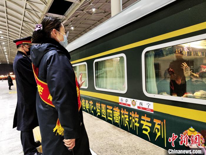 图为西宁站工作人员欢送首趟进藏旅游专列的旅客 杨红健 摄