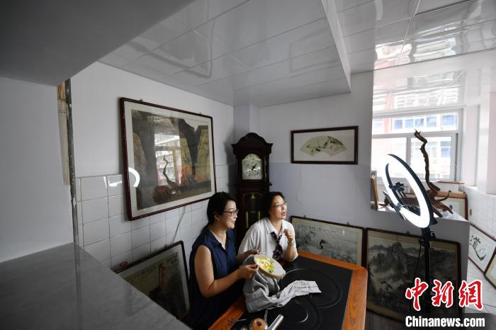 图为刘玉霞(右)通过视频直播与新加坡刺绣爱好者交流。　翟羽佳 摄